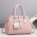Dettaglio della borsa tote rosa intrecciata con fibbia dorata e mini ciondolo decorativo - Rosa