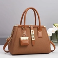 Dettaglio trama intrecciata su borsa tote marrone con accessori dorati e pochette - Giallo Terra