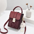 Structured burgundy crossbody phone bag in faux snakeskin texture with a plush charm - Burgundy