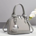 Close-up of grey shell bag with dual zippers, heart pendant, and leather texture - Gray