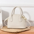 Beige lychee pattern leather satchel with dual handles and gold hardware on woven mat - Off-white