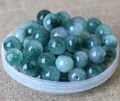Macro detail of natural jadeite loose beads with green veins for DIY jewelry making - 8mm / Floating Blue