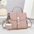Detail view of mauve lychee grain leather handbag with silver lock and mini bag charm - Pink