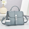 Detailed side view of a blue-grey pebble leather handbag with silver metallic buckle and charms - Blue