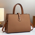 Brown textured leather crossbody tote bag with gold hardware shown in home setting - Khaki/Earth Yellow
