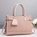 Detail of pink woven texture handbag with golden hardware and mini bag charm - Pink