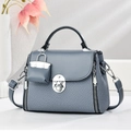 Sac bandoulière bleu-gris texturé avec fermoir rotatif argenté et mini breloque - Bleu