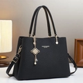 Primer plano detallado del bolso bandolera negro con textura de sarga y colgante de perlas - Negro