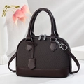 Close-up of shell-shaped striped leather bag with dual zippers and silver hardware - Coffee