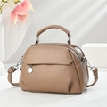 Close-up of litchi pattern leather handbag featuring dual zippers and metal pendant detail - Khaki