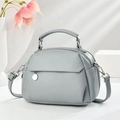 Detail of grey lychee leather texture with silver round pendant and dual zipper closures - Sky Blue