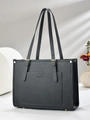 Gros plan d'un sac cabas en cuir grainé noir avec boucles et rivets en métal doré élégants - Gris clair