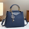 Detail of navy blue crossbody bag with gold three-ring handle and rhinestone pendant - Blue