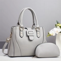 Close-up of light gray quilted tote bag set with golden hardware and matching pouch - Gray