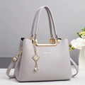 Sac à main chic gris grainé avec détails dorés et breloque à pompon en perles - Gris