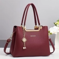 Detail der burgunderroten Handtasche mit Lychee-Leder, Gold-Hardware und Perlenanhänger - Rot