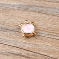 Detail eines rosa Emaille-Wecker-Anhängers mit Goldmetallrahmen für DIY-Schmuck - Rosa