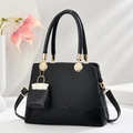 Elegant black woven handbag for women with matching mini charm and gold metal accents - Black