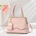 Pink textured fabric and smooth leather handbag with gold metal handles and flower accents - Pink