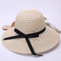 Women's summer straw sun hat with wide brim and black ribbon bow on white background - Beige