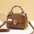 Elegant brown woven leather crossbody handbag with silk scarf handle and mini bag charm - Earthy Yellow