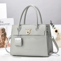 Dettaglio della borsa grigio chiaro con trama a litchi, chiusura dorata e mini pochette - Grigio