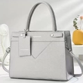 Light grey crossbody bag in lychee pattern leather with V-shaped stitching and top handles - Gray