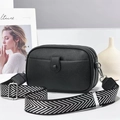 Detail view of black lychee grain mini crossbody bag with triple zipper and woven strap - Black