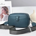 Blue lychee leather mini crossbody bag with wide woven strap on a white surface - Blue
