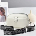 Detail of white lychee leather camera bag with wide chevron strap and silver hardware - White
