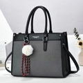 Dettaglio della grande borsa tote in pelle nera e tessuto grigio con scritta di moda - Nero