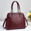 Dettaglio della borsa in pelle trapuntata bordeaux con catena nera elegante - Rosso Vino