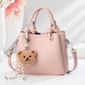 Borsa a mano in pelle rosa con manici a nodo e ciondolo a orsetto in un set moderno - Rosa
