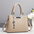 Détail du sac à main beige texture litchi avec breloque trèfle et finitions argentées - Kaki