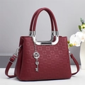 Sac à main bordeaux en cuir gaufré avec bandoulière et pendentifs en métal argenté - Rouge