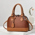 Macro shot of brown lychee leather handbag with dual metal zippers on a white stone base - 23.5x10.5x17cm / Earthy Yellow