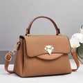 Detailed side view of caramel textured handbag with golden triangular metal buckle - Earthy Yellow