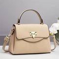 Dettaglio della trama intrecciata beige e della chiusura dorata sulla borsa chic - Cachi