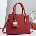 Elegant red textured PU leather handbag for women featuring gold hardware and a shoulder strap - Red