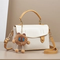 Detalle de textura tejida en espiga y solapa de cuero con charm de oso suave - Blanco Roto
