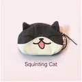 Close-up of plush cat coin purse with bicolored pattern and pink tongue detail - Tuxedo Cow Cat