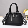 Detail of black lychee grain leather shell bag with silver bear charm and wide strap - Black Solid