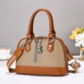 Close-up of brown textured leather shell bag with bear charm and woven strap - Earth Yellow Khaki