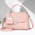 Detalle de bolso bandolera rosa claro con solapa trenzada y hebilla metálica en forma de G - Rosa Claro