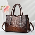 Detail shot of a dark brown crocodile texture handbag with silver metal hardware - Coffee