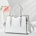 Detail of white crocodile texture handbag with silver hardware and chic top handle - White