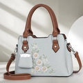 Detailansicht der Canvas-Handtasche mit Gänseblümchen-Stickerei und Ledergriffen - Blau