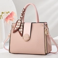 Pink fabric handbag with silk scarf and gold clasp detail in a clean studio setting - Pink