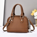 Détail du sac coquille marron caramel avec texture grainée et breloque coeur - Jaune Terre