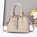 Détail du sac à main beige en cuir grainé avec breloques cœur et glands métalliques - Khaki Clair